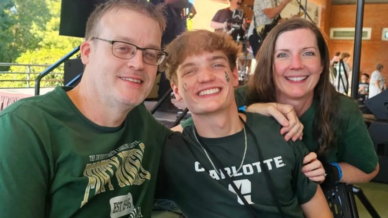 Danny Powers poses in Charlotte gear with his family at an event in the alumni complex