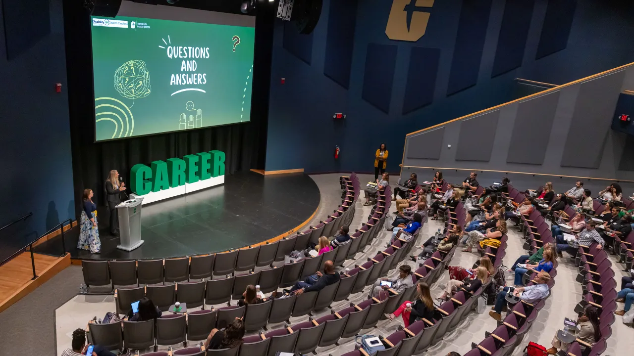 Employers in attendance at the employer symposium held inside of mcknight hall; aerial view of the room and stage