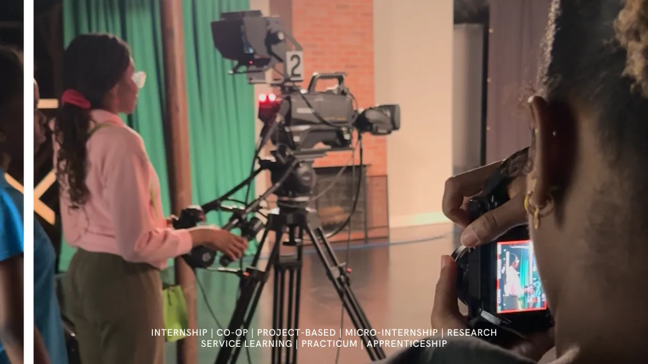 secu summer intern taking photos of students controlling video and audio production at a local studio