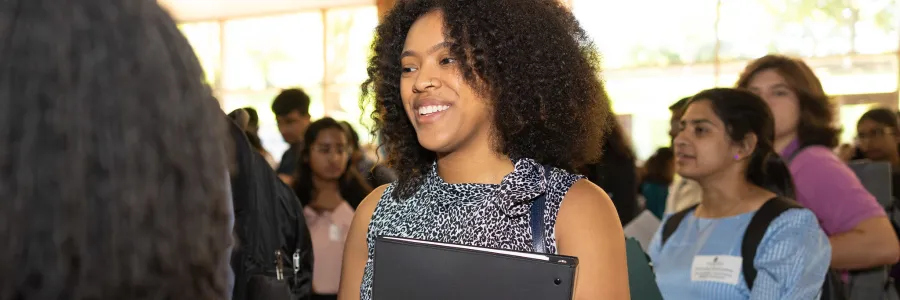 Student at the career fair smiling talking to a recruiter