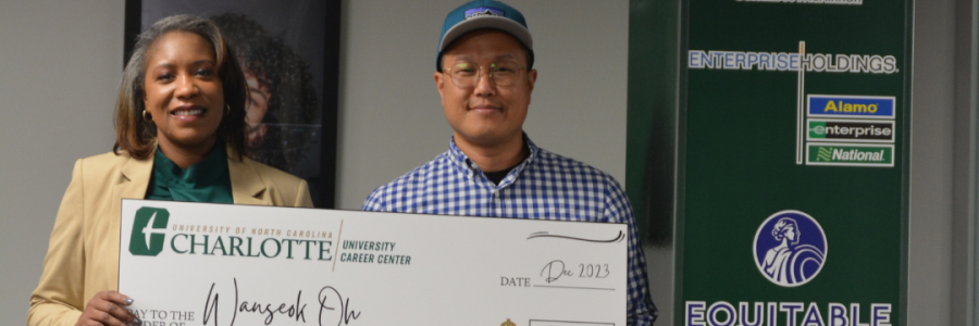 Wanseok Oh poses with the columbus mckinnon employer, they are both holding the large 3500 dollar check he won through the career challenge