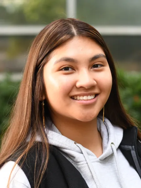 Leery smiles at the camera with a blurred greenery background