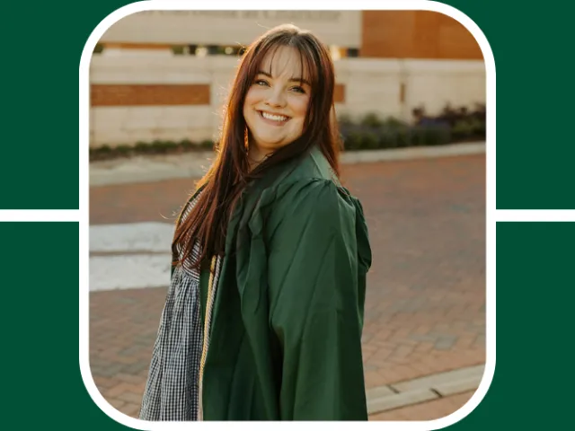Abbey Burgess poses in her green graduation gown at the main entrance of UNC Charlotte