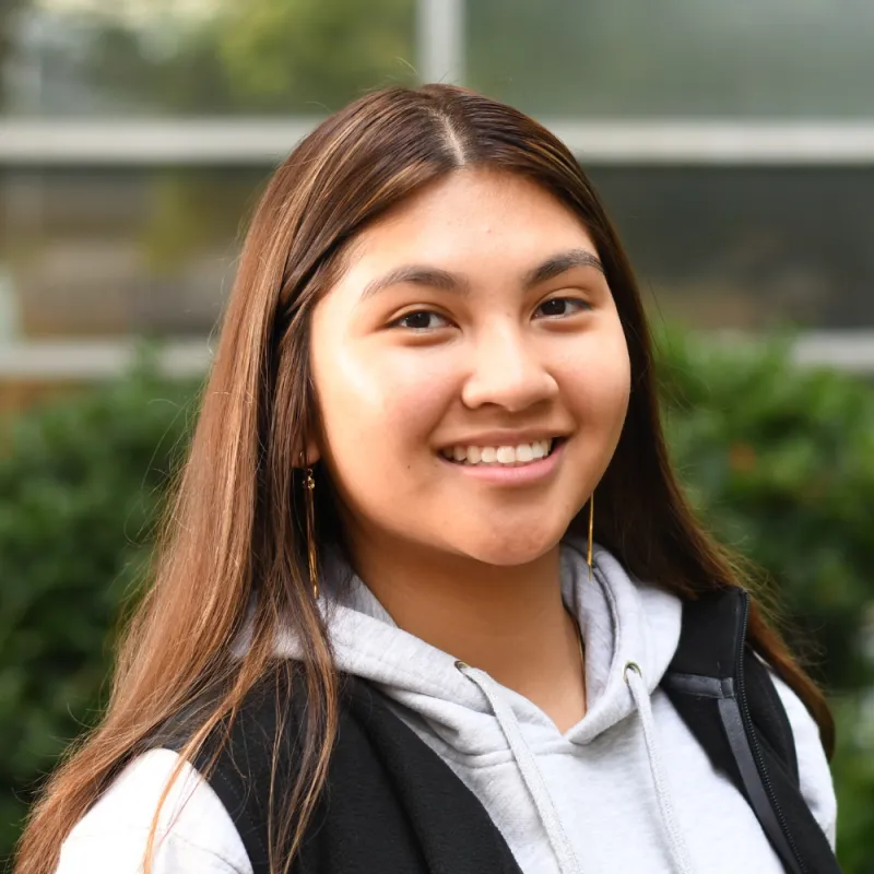 Leery smiles at the camera with a blurred greenery background