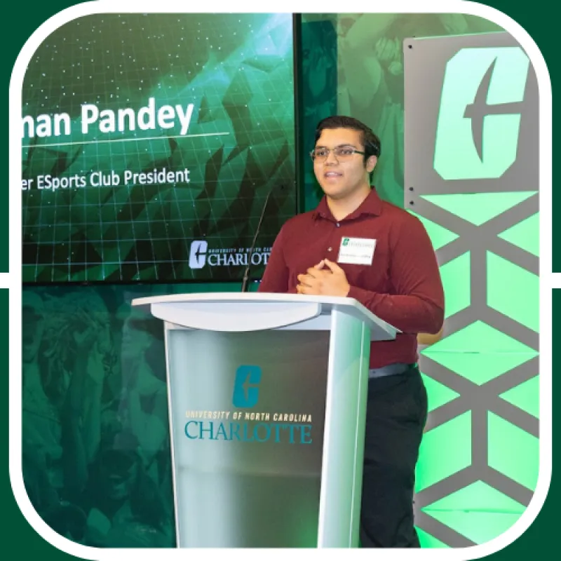 Anshuman stands at the Charlotte podium during an Esports event, speaking to a crowd