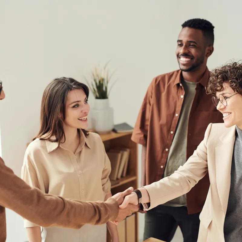 Two people shaking hands while two people watch